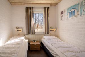 a room with two beds and a window at Hoogelandt 92 in De Koog