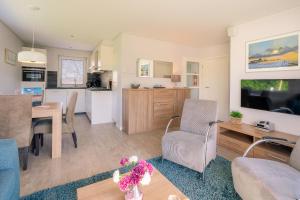 a living room and kitchen with a table and chairs at Hoogelandt 92 in De Koog