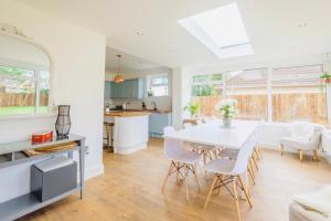 a kitchen and dining room with a white table and chairs at Gorgeous Luxury Chalet, New Forest & Coast & in Hordle