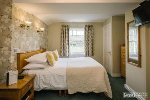 a bedroom with a bed and a window at Three Shires Inn in Little Langdale