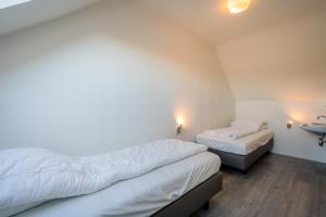 1 dormitorio con 2 camas y lavamanos. en Nieuwlanderweg 57 en De Waal