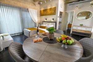 a room with a table with fruit on it with a bed at אחוזת מיא - סוויטות בוטיק על המים in Goren