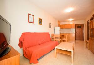 a living room with a red couch and a kitchen at APCOSTAS Los Iris - familiar in Playa de Gandia