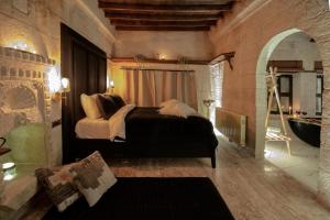 a bedroom with a bed in a room with a mirror at Sato Cave Hotel in Göreme