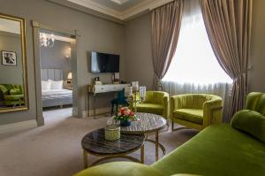 a living room with a couch and chairs and a table at Hotel Lido by Phoenicia in Bucharest