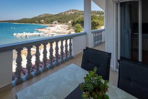 a balcony with a table and a view of the water at Apartmani "MARKO" Dugovača in Drage