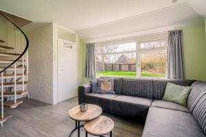a living room with a couch and a window at Nieuwlanderweg 65 in De Waal