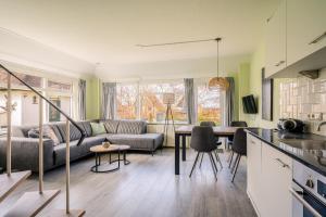 a kitchen and living room with a couch and a table at Nieuwlanderweg 65 in De Waal