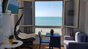 a living room with a hammock and a view of the beach at Arteg Apartments - Full Sea View in Durrës