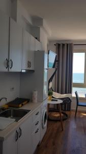 a kitchen with a sink and a table with at Arteg Apartments - Full Sea View in Durrës