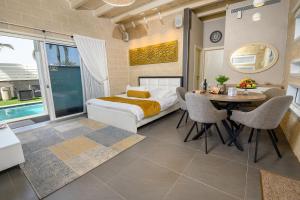a bedroom with a bed and a table with chairs at אחוזת מיא - סוויטות בוטיק על המים in Goren