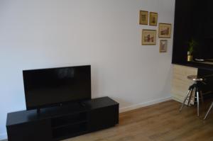 a flat screen tv sitting on top of a black entertainment center at Perla Gdańsk in Gdańsk