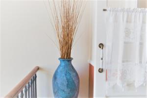 a blue vase sitting on a staircase next to a window at Egli Hotel in Andros
