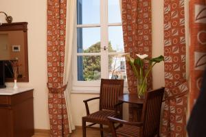 a dining room with a table and two chairs and a window at Egli Hotel in Andros