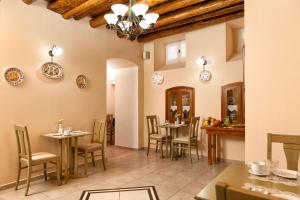 a restaurant with tables and chairs in a room at Egli Hotel in Andros