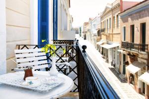 a table on a balcony with a vase of flowers at Egli Hotel in Andros