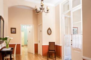 a hallway with a table and chairs and a chandelier at Egli Hotel in Andros