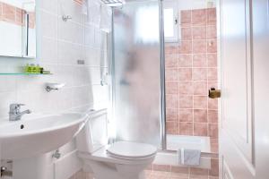a bathroom with a toilet and a sink and a shower at Egli Hotel in Andros