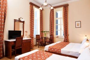 a hotel room with two beds and a television at Egli Hotel in Andros
