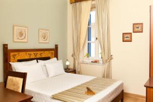 a bedroom with a bed with a table and a window at Egli Hotel in Andros