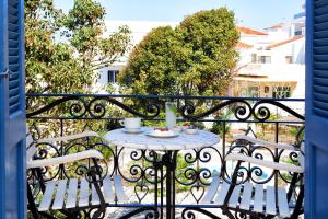 an outdoor balcony with a table and chairs at Egli Hotel in Andros