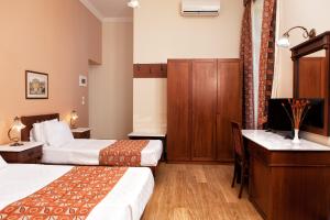 a hotel room with two beds and a sink at Egli Hotel in Andros