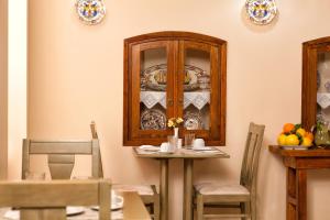a dining room with a table and a china cabinet at Egli Hotel in Andros