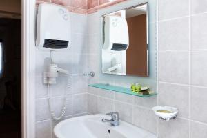 a bathroom with a sink and a mirror at Egli Hotel in Andros