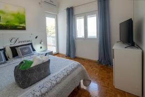 a bedroom with a bed and a flat screen tv at Apartmani "MARKO" Dugovača in Drage