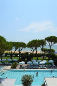 uma grande piscina com cadeiras e guarda-sóis em Hotel Bauer & Sporting em Lido di Jesolo