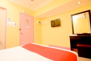 a bedroom with a bed and a mirror and a tv at OYO 89958 Hotel Umimas in Lahad Datu