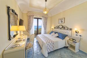 a bedroom with a bed and a desk and a window at Hotel Terme Tritone Resort & Spa in Ischia +37 photos