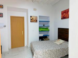 - une chambre avec un lit et une porte en bois dans l'établissement Nerja CityCenter Bajo, à Nerja