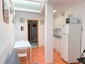 Il comprend une cuisine équipée d'un réfrigérateur blanc et d'une table. dans l'établissement Nerja CityCenter Bajo, à Nerja