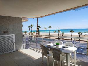 einen Tisch und Stühle auf einem Balkon mit Blick auf den Strand in der Unterkunft Pompeya Vista Mar Orangecosta in Peñíscola