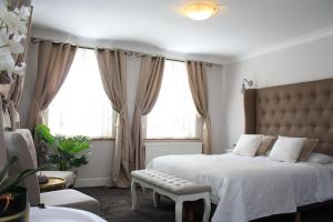 a bedroom with a bed and a chair and windows at Hotel Vredehof in Damme