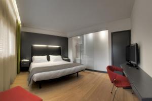 a bedroom with a bed and a flat screen tv at Mercure Nerocubo Rovereto in Rovereto