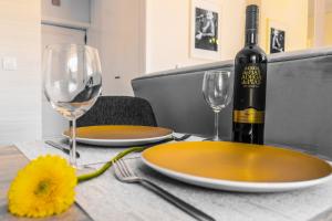 - une table avec deux assiettes et une bouteille de vin dans l'établissement Aveiro, Ria e Fado, à Aveiro