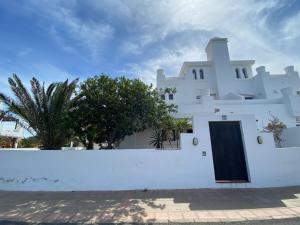 a white house with a door on a wall at Royal Park Guesthouse in Corralejo