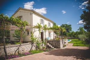 une maison blanche avec un chemin à côté d'un bâtiment dans l'établissement Village Villa „ M „, à Malinska