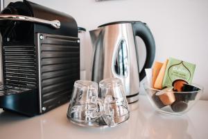 a counter top with a toaster and two glass cups at Djupvasshytta Bed & Breakfast in Geiranger