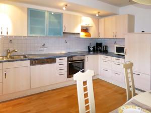 una cucina con mobili bianchi e un lavandino di Apartment Weberbauer-3 by Interhome a Hollersbach im Pinzgau