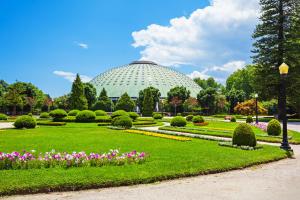 a conservatory with a garden with flowers and trees at Vilar Charming Studio - Palácio de Cristal in Porto