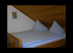 - un lit avec 2 oreillers dans l'établissement Ferienhaus Jupp-Schöttler-Jugendherberge, à Finnentrop