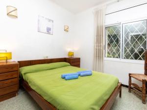 sypialnia z łóżkiem z zieloną pościelą i oknem w obiekcie Apartment Cambre d'Aze by Interhome w mieście Llança
