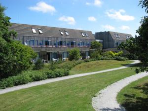 una casa con un sentiero che porta a un edificio di Appartement Kompas a Hollum