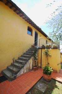 een geel huis met een trap ervoor bij La Casa delle Rose in Terranuova Bracciolini