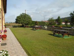 two picnic benches sitting in a grassy yard at Turismo Rural El Gobernador in Villaviciosa