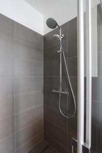 een douche met een douchekop in de badkamer bij Hotel Rodgau in Rodgau