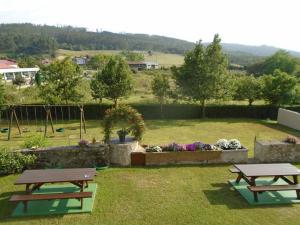 two picnic tables in a field with a garden at Turismo Rural El Gobernador in Villaviciosa +32 photos